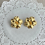 Gold floral earrings on a white dolly, flower earrings