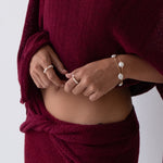 Woman wearing a burgundy off-shoulder top against a white background